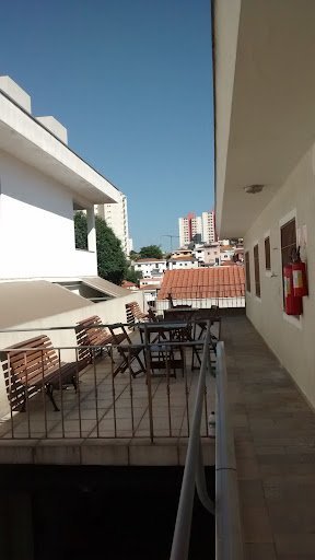 Terraço arejado com bancos de madeira em um dia de céu limpo na Casa de Repouso Villaggio