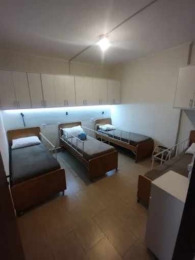 Quarto compartilhado no Vila Harmonia com quatro camas hospitalares de madeira organizadas, iluminação embutida sob armários suspensos brancos e piso cerâmico claro. Quarto compartilhado no Vila Harmonia com quatro camas hospitalares de madeira organizadas, iluminação embutida sob armários suspensos brancos e piso cerâmico claro.